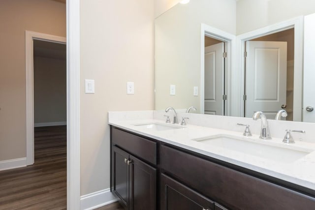 5587 Spring St, Flowery Branch, GA 30542 - bathroom with baseboards, a sink, wood finished floors, and double vanity