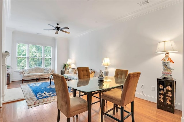 dining area featuring light hardwood / wood-style flooring, ceiling fan, and crown molding