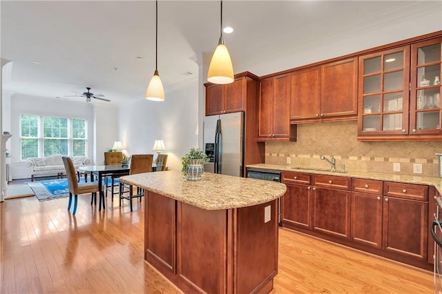 kitchen with decorative light fixtures, tasteful backsplash, sink, stainless steel fridge with ice dispenser, and light hardwood / wood-style floors