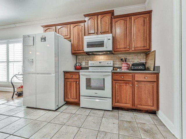 kitchen with crown molding, white appliances, light tile patterned flooring, and backsplash