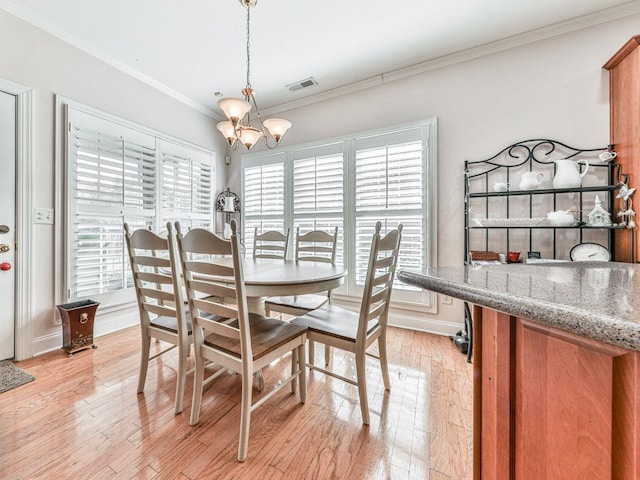 dining room featuring crown molding, a notable chandelier, and light wood-type flooring