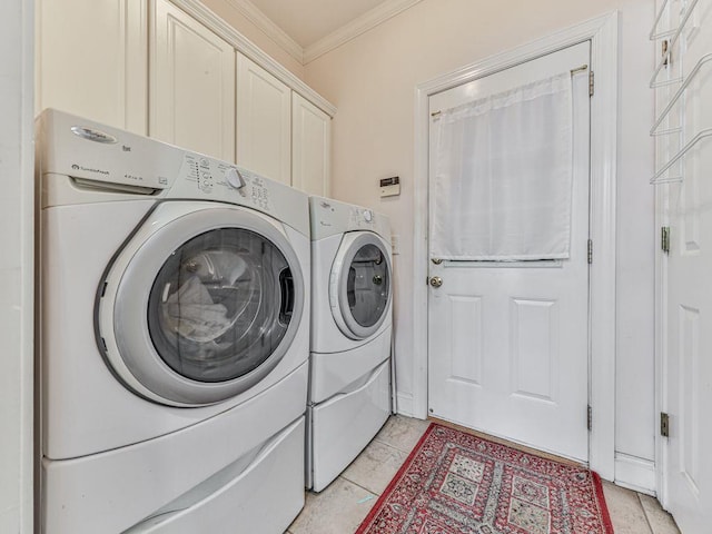 washroom with crown molding, cabinets, washing machine and dryer, and light tile patterned floors