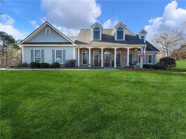 cape cod-style house featuring covered porch and a front lawn