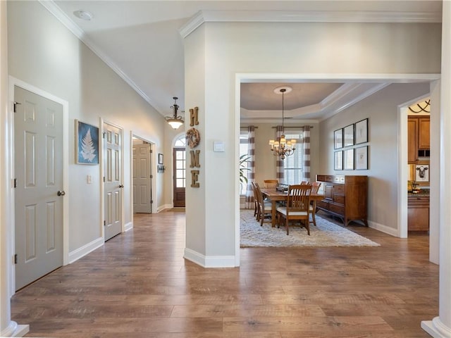 dining space featuring crown molding, dark hardwood / wood-style floors, a raised ceiling, and a chandelier