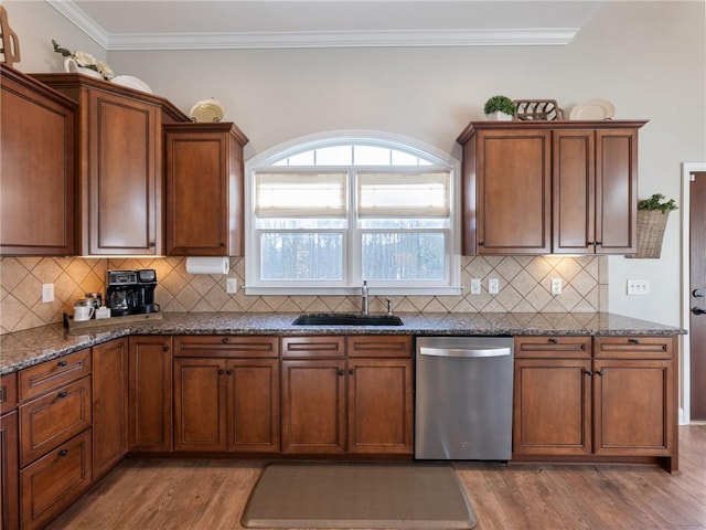 kitchen featuring dark stone counters, sink, backsplash, hardwood / wood-style flooring, and stainless steel dishwasher