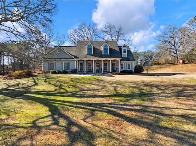 cape cod home featuring covered porch and a front yard