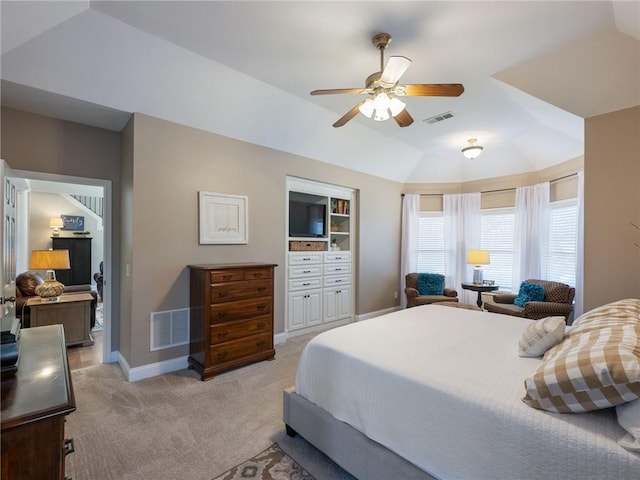 bedroom with light carpet, ceiling fan, and a tray ceiling