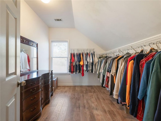 walk in closet featuring hardwood / wood-style floors and vaulted ceiling