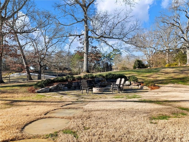 view of community with a lawn and an outdoor fire pit