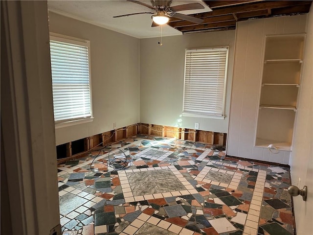 empty room with ceiling fan and tile patterned flooring