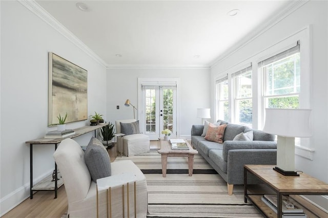 living room featuring plenty of natural light, french doors, crown molding, and light wood-type flooring