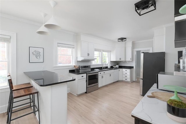 kitchen featuring white cabinetry, hanging light fixtures, light wood-type flooring, and stainless steel appliances