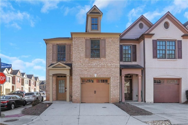 multi unit property featuring concrete driveway, an attached garage, and brick siding