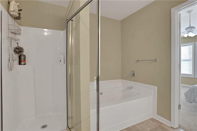 bathroom with a stall shower, baseboards, and a garden tub