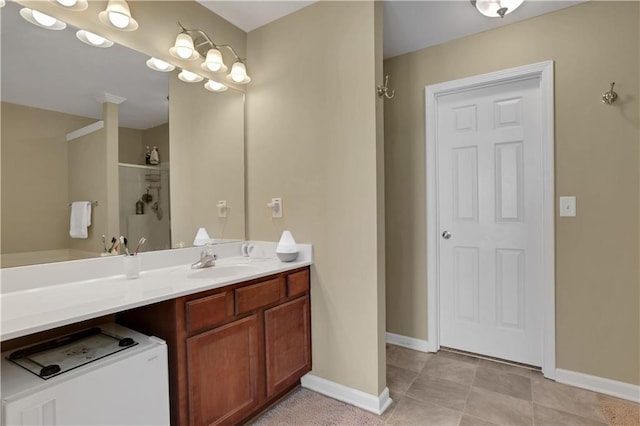 full bath with baseboards, vanity, and walk in shower