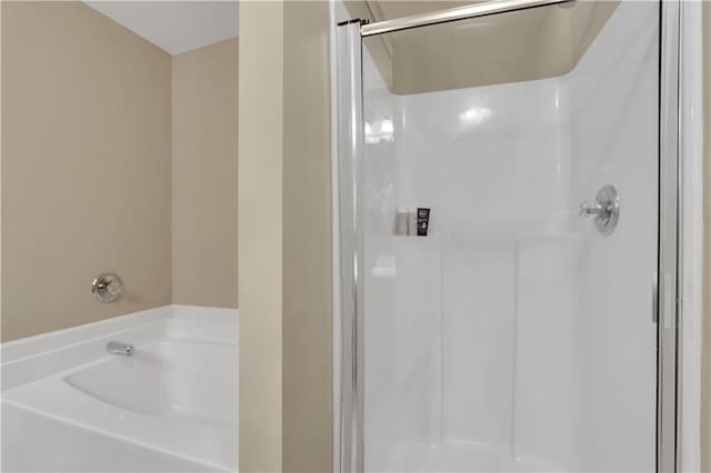 bathroom featuring a stall shower and a garden tub