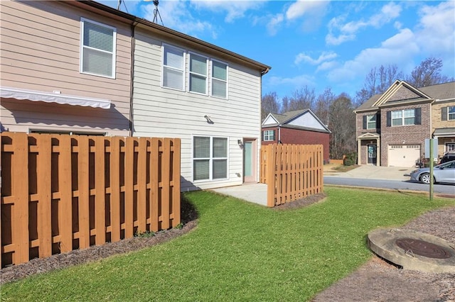 back of house featuring a lawn and fence