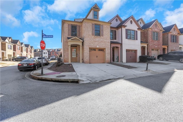 multi unit property featuring an attached garage, brick siding, a residential view, and driveway