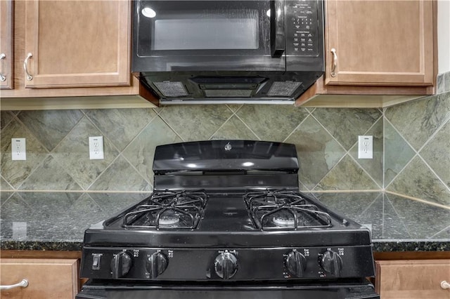 kitchen featuring dark stone counters, backsplash, and black appliances