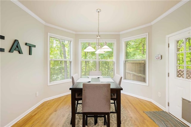 dining space with light wood-type flooring, baseboards, and ornamental molding