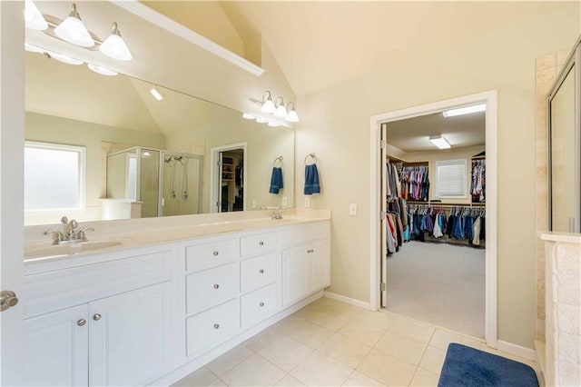 full bath featuring vaulted ceiling, a stall shower, double vanity, a spacious closet, and tile patterned flooring
