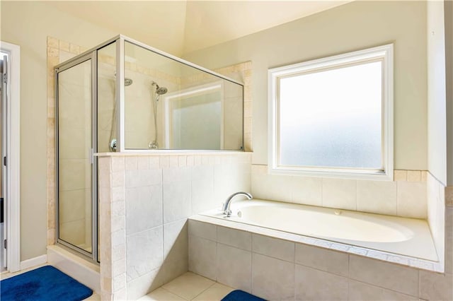 full bathroom with a shower stall and a bath