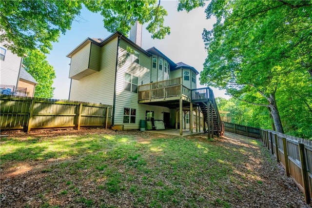 back of property featuring a wooden deck, a fenced backyard, a chimney, stairs, and a patio