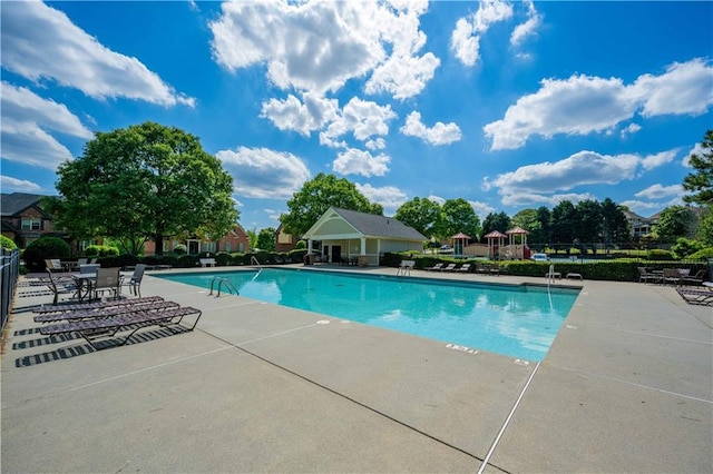 community pool with fence and a patio