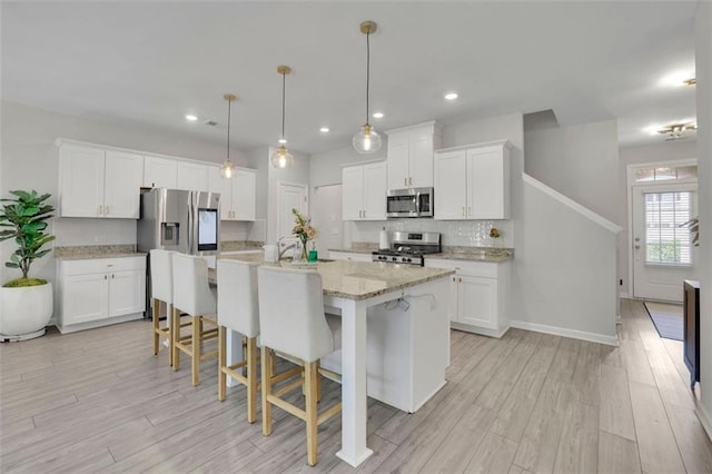 1969 Lanier Harbor Pt, Buford, GA 30518 - kitchen with appliances with stainless steel finishes, light wood-type flooring, white cabinetry, and recessed lighting