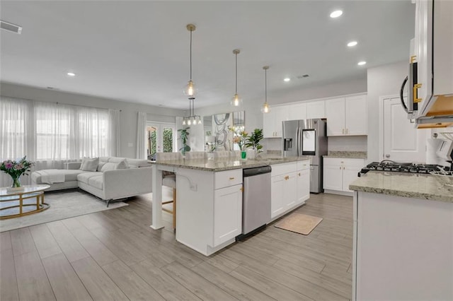 1969 Lanier Harbor Pt, Buford, GA 30518 - kitchen featuring stainless steel appliances, open floor plan, light wood finished floors, a kitchen breakfast bar, and recessed lighting