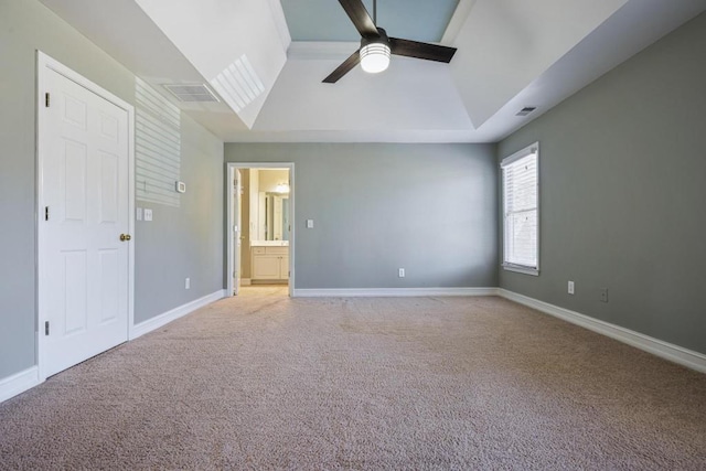 unfurnished bedroom with ceiling fan, lofted ceiling, connected bathroom, and light carpet