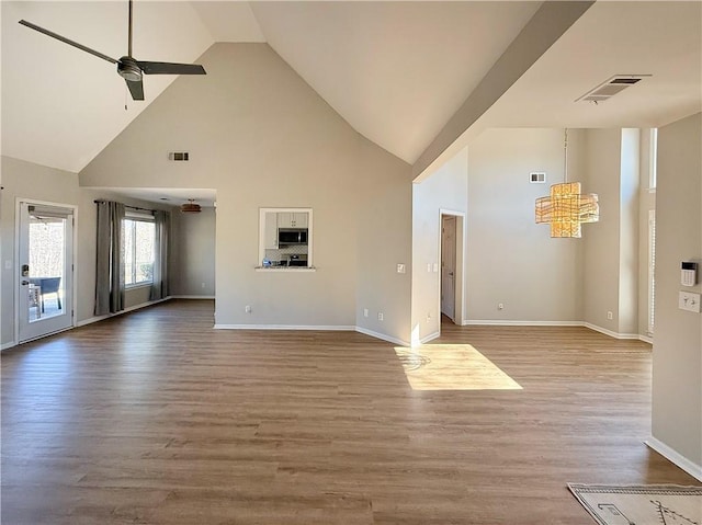 unfurnished living room featuring baseboards, light wood-style flooring, visible vents, and a ceiling fan