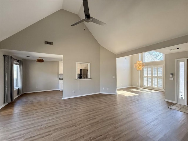 unfurnished living room with visible vents, plenty of natural light, and wood finished floors