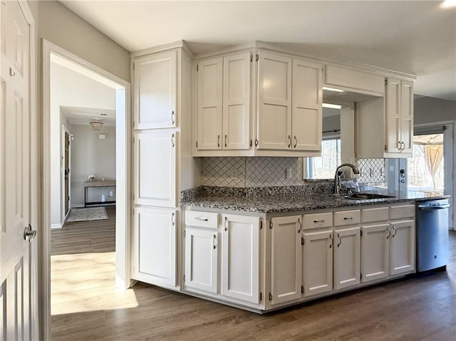 kitchen featuring a sink, white cabinets, dishwasher, tasteful backsplash, and dark wood finished floors