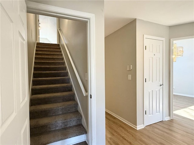 stairway featuring baseboards and wood finished floors