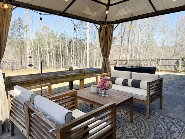 view of patio / terrace with fence, a gazebo, and an outdoor hangout area