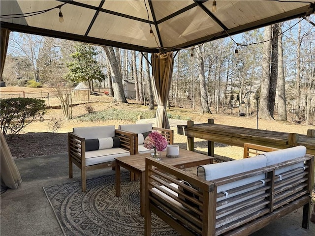 view of patio featuring fence, an outdoor living space, and a gazebo