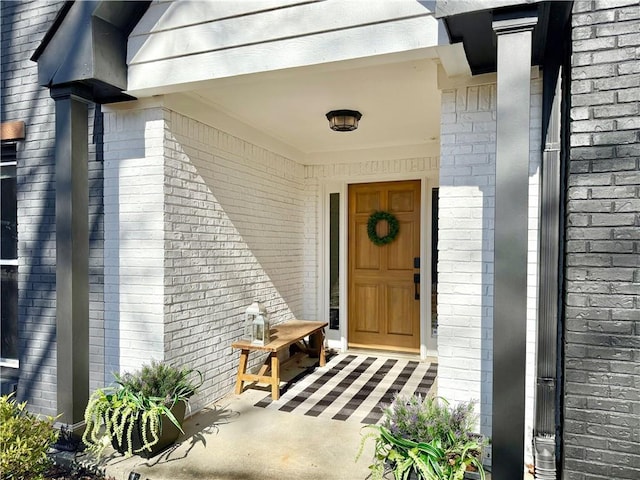 entrance to property featuring brick siding