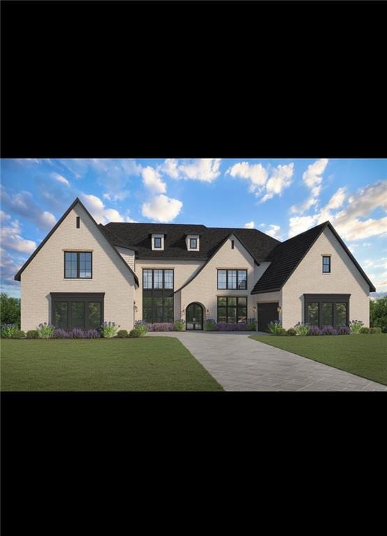 view of front of property featuring a garage, driveway, and a front lawn