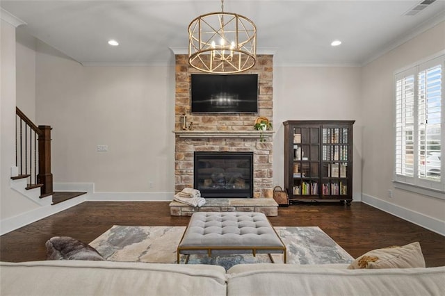 living room with a notable chandelier, crown molding, a fireplace, and dark wood-type flooring