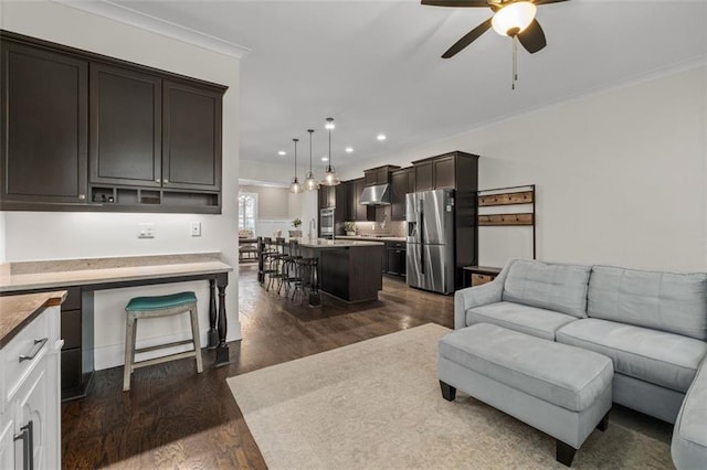 living room with ornamental molding, dark hardwood / wood-style floors, and ceiling fan