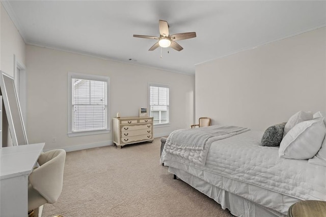 carpeted bedroom with ornamental molding and ceiling fan