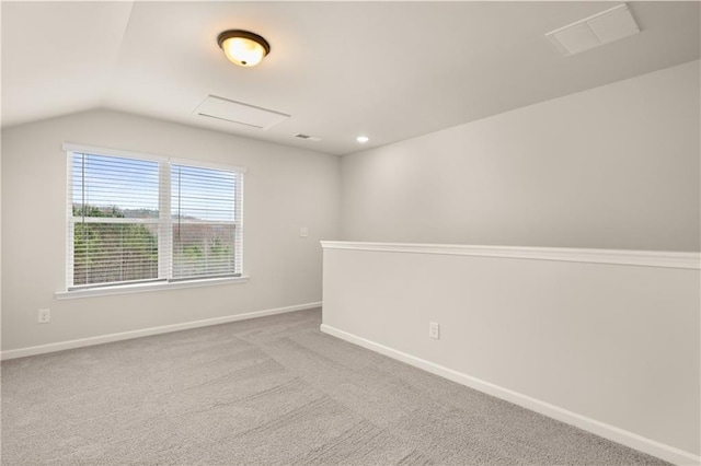 unfurnished room featuring recessed lighting, light colored carpet, baseboards, vaulted ceiling, and attic access