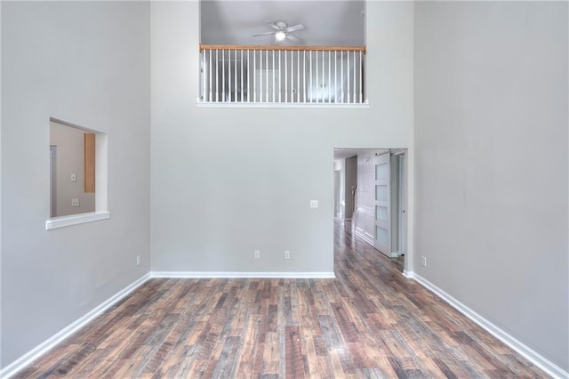 4041 Ash Tree St, Snellville, GA 30039 - spare room featuring a high ceiling, a ceiling fan, wood finished floors, and baseboards