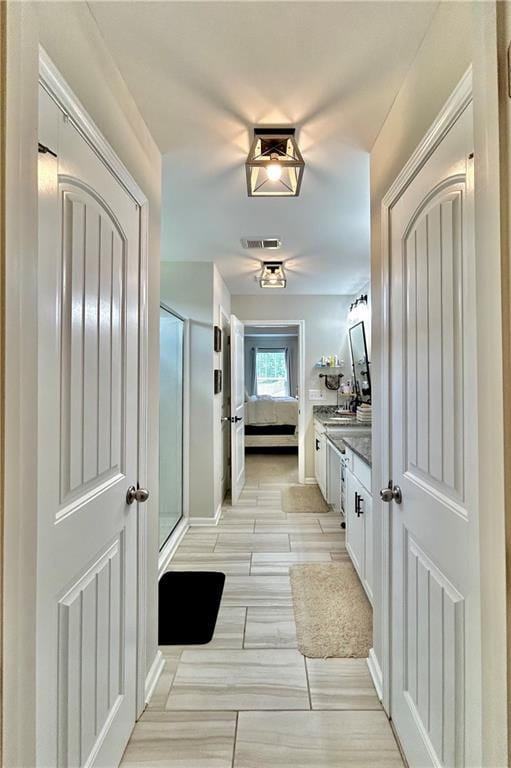 full bath featuring a shower stall, vanity, and ensuite bathroom