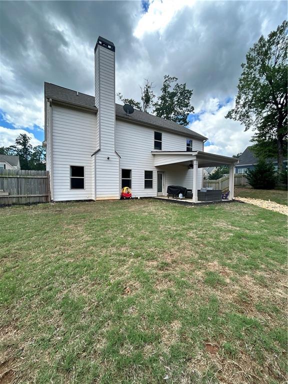 back of house featuring a chimney and a patio area