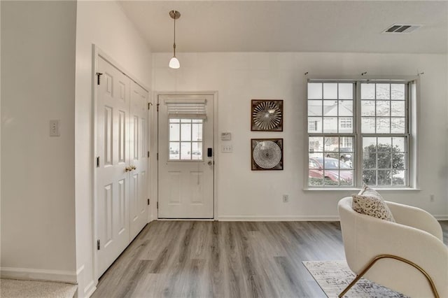 foyer entrance featuring light wood-style floors, visible vents, and baseboards