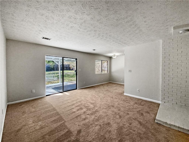 carpeted empty room featuring a textured ceiling