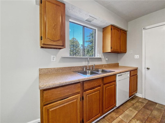 kitchen with white dishwasher, sink, and a textured ceiling