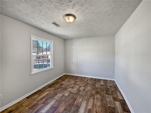 unfurnished room with dark hardwood / wood-style flooring and a textured ceiling